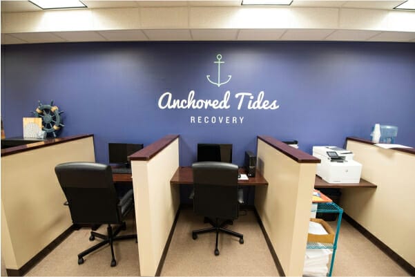 blue wall that says 'anchored tides recovery' in the office with partition