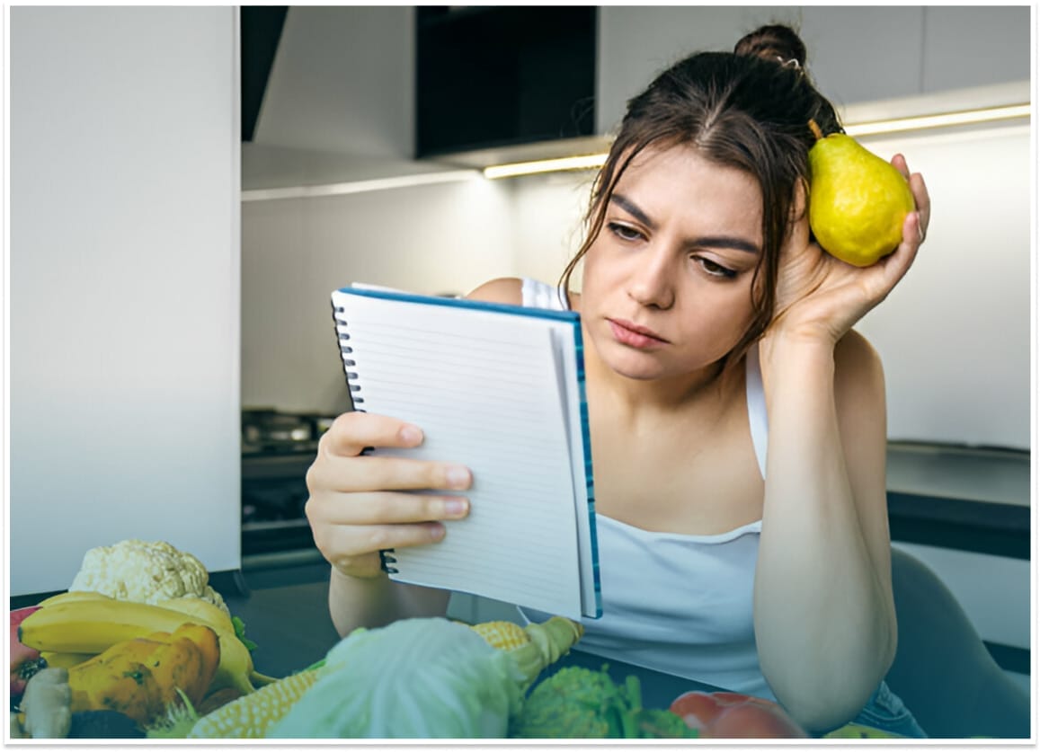 Woman obsessively arranging healthy food, showcasing orthorexia disorder.