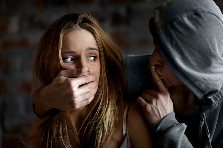 A man forcefully covering a woman's mouth with his hand, his face partially obscured, symbolizing control and silencing in narcissistic abuse. The woman’s eyes reflect fear and helplessness