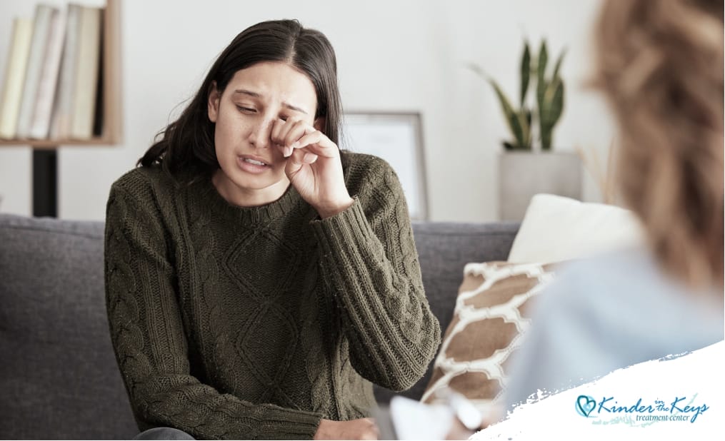 A woman sitting in a therapist's office, speaking to a mental health professional, expressing her concerns while the therapist listens attentively, creating a supportive and empathetic environment.