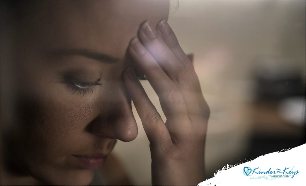 A close-up of a girl's hand resting against a window, with a melancholic and sad expression reflected in the glass, symbolizing loneliness and deep contemplation.