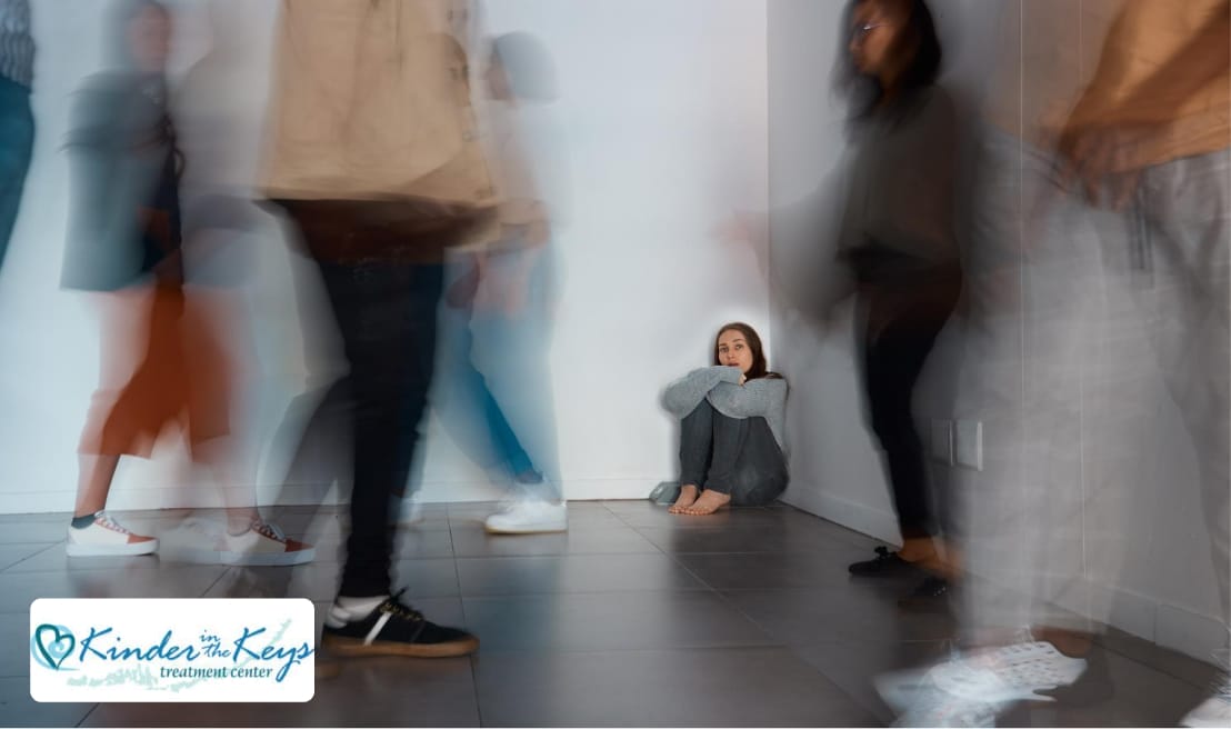 Lonely woman sitting in a corner while blurred figures of people walk past, symbolizing isolation and disconnection