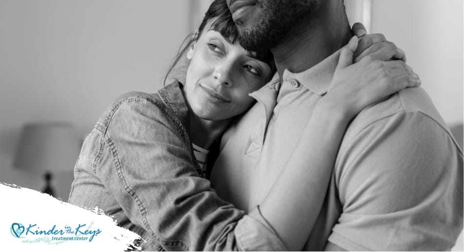 Woman embraces partner, finding comfort and healing after PTSD from narcissistic abuse.