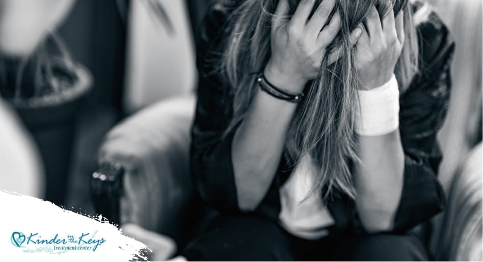 Woman in distress holding head, symbolizing PTSD from narcissistic abuse.