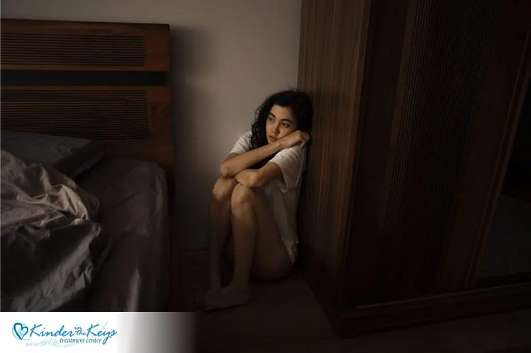 Woman sitting alone in distress, showing the need for CBT in trauma recovery.