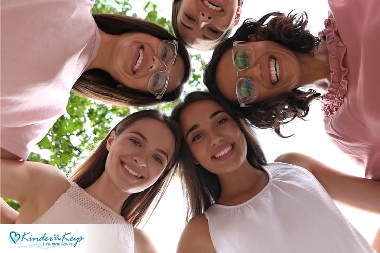 Group of smiling women outdoors, showing community support in holistic recovery.